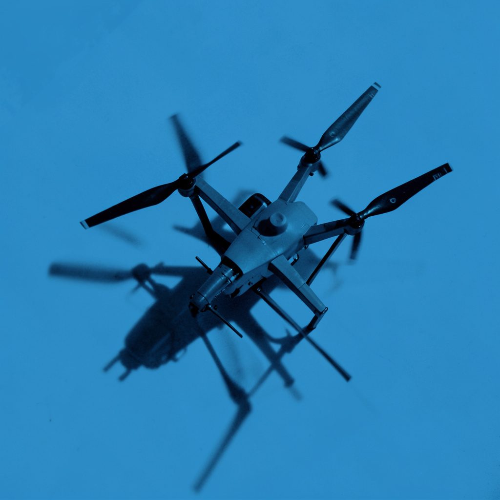 Drone hovering above an open field with a tablet display showing mapping data in the foreground